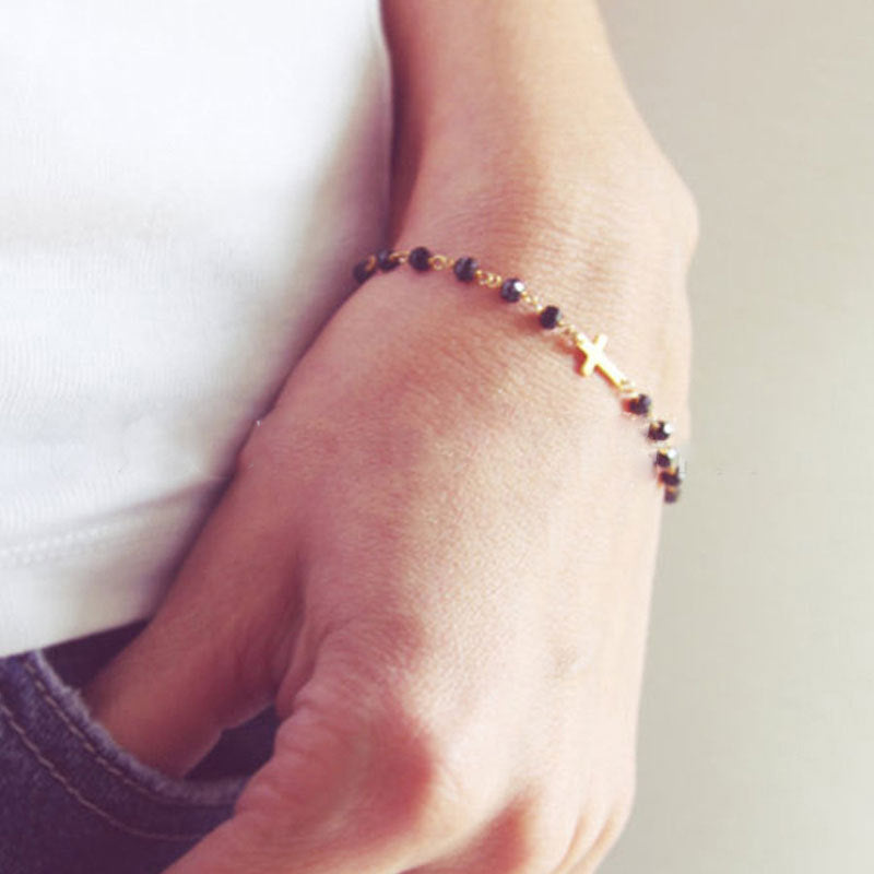 Delicate cross bracelet featuring an obsidian beads with gold-plated cross